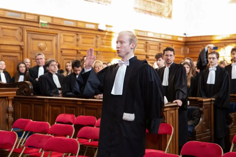 Maître Maximilien Dechamps, en robe, prononce le serment de l’avocat dans une salle d’audience.